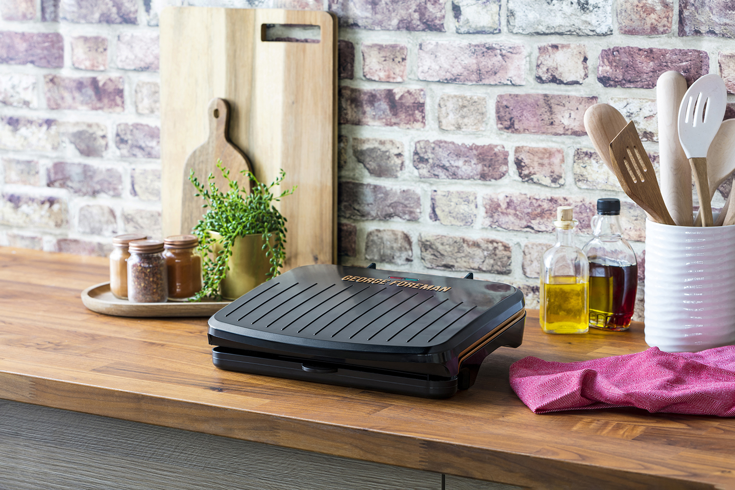 Kitchen scene with a George Foreman grill on a wooden countertop.