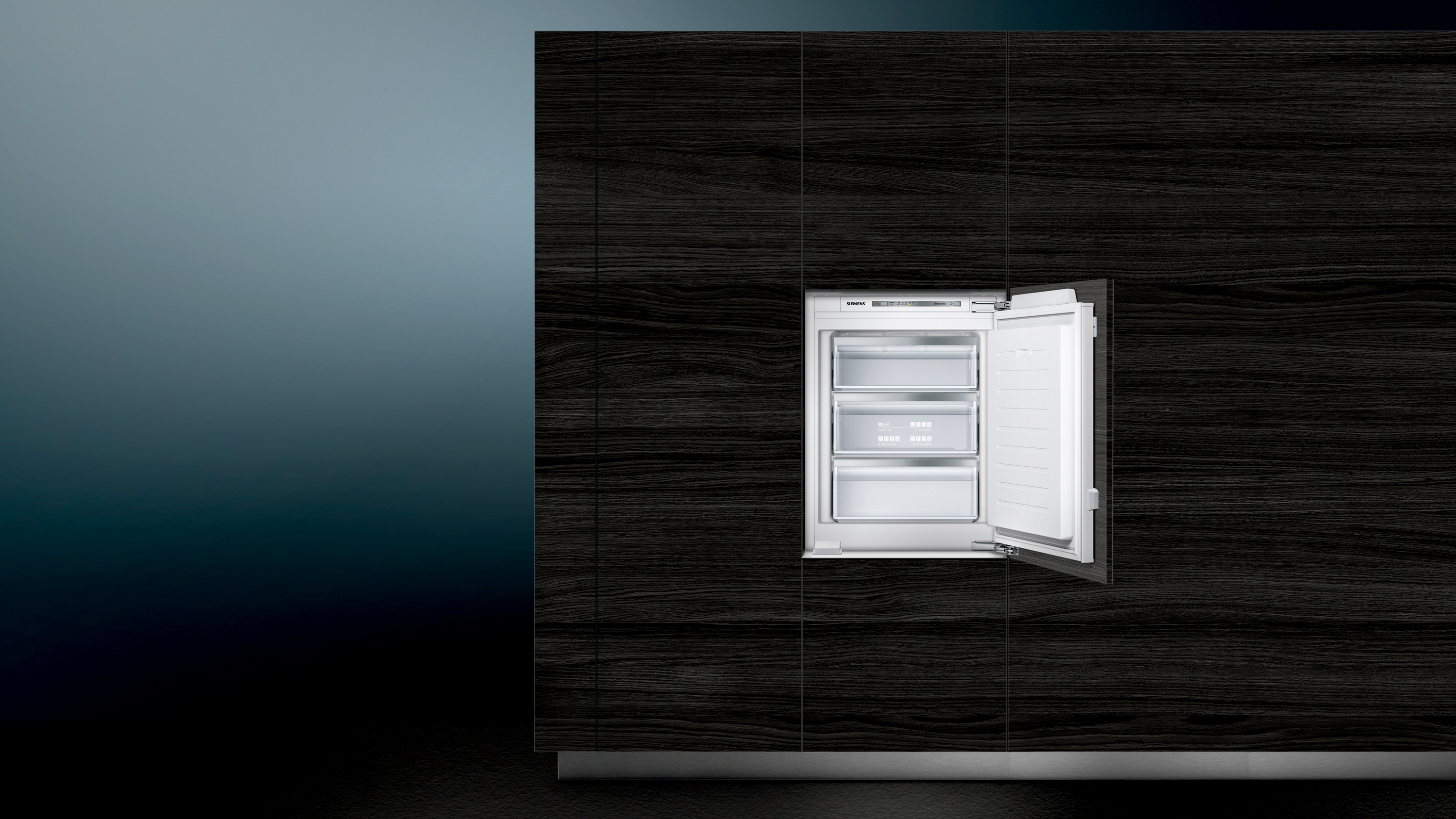 Einbaukühlschrank mit offener Tür. Dunkle Holzverkleidung an der Wand.