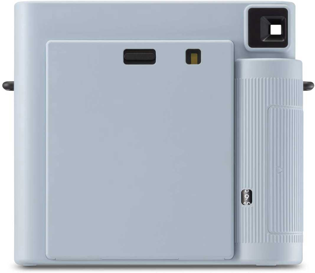 The back of a light blue instant camera. It has a film door, a viewfinder, and a slot for the film cartridge.