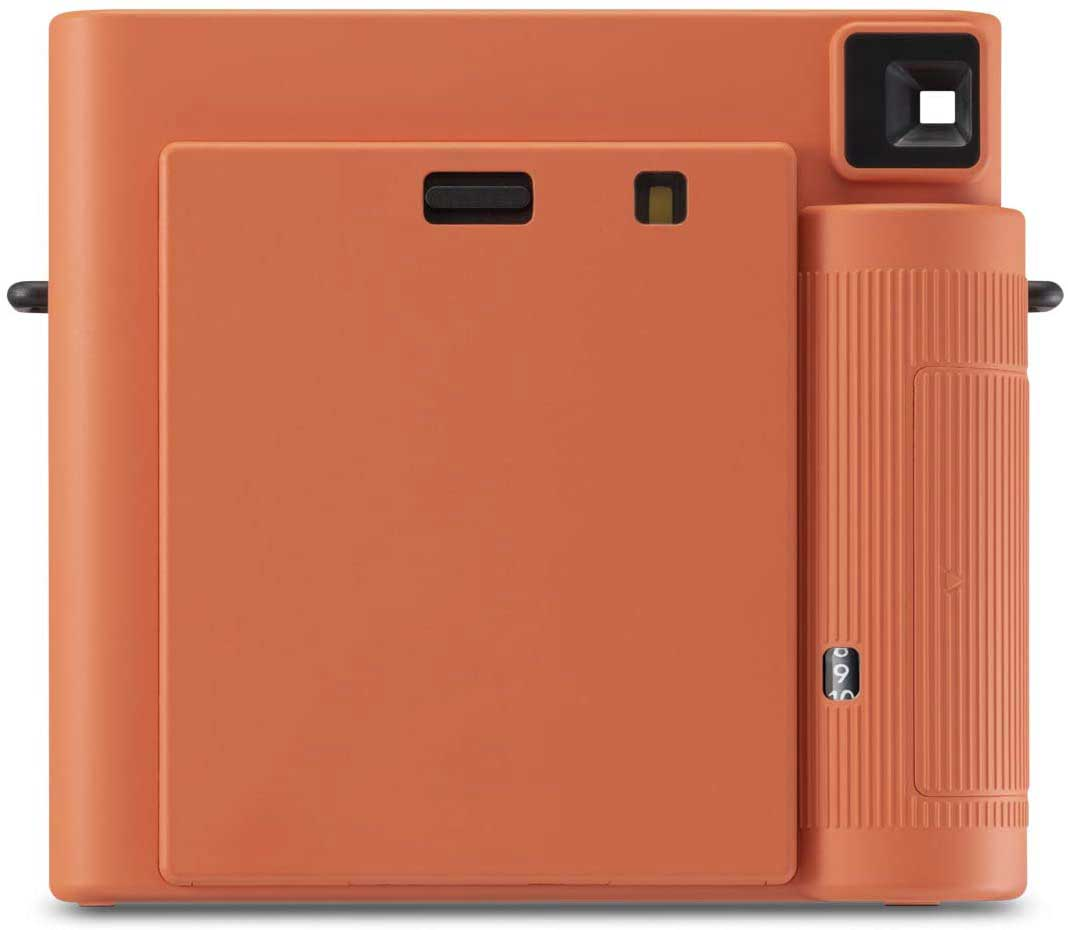 Orange instant camera, back view, square lens, shutter button.