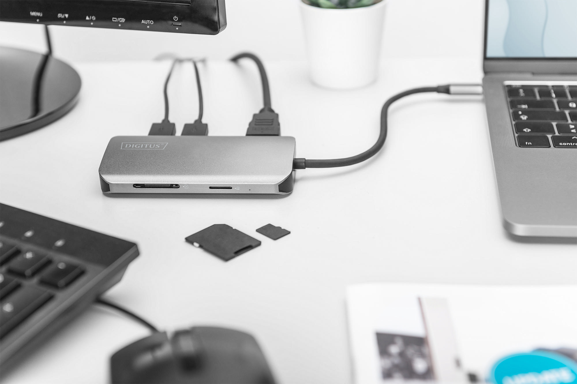 Ein Laptop, verbunden mit einem Hub, mit Karten und anderen Gegenständen.