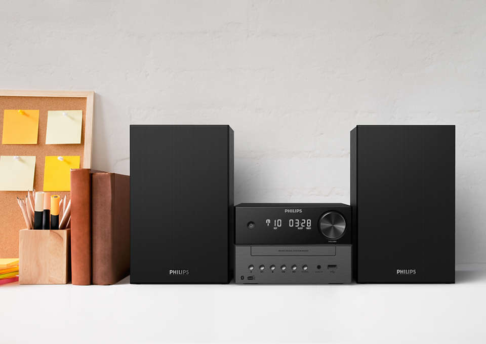 Ein schwarzes Philips-Stereosystem mit zwei Lautsprechern und ein paar Gegenständen auf dem Schreibtisch.
