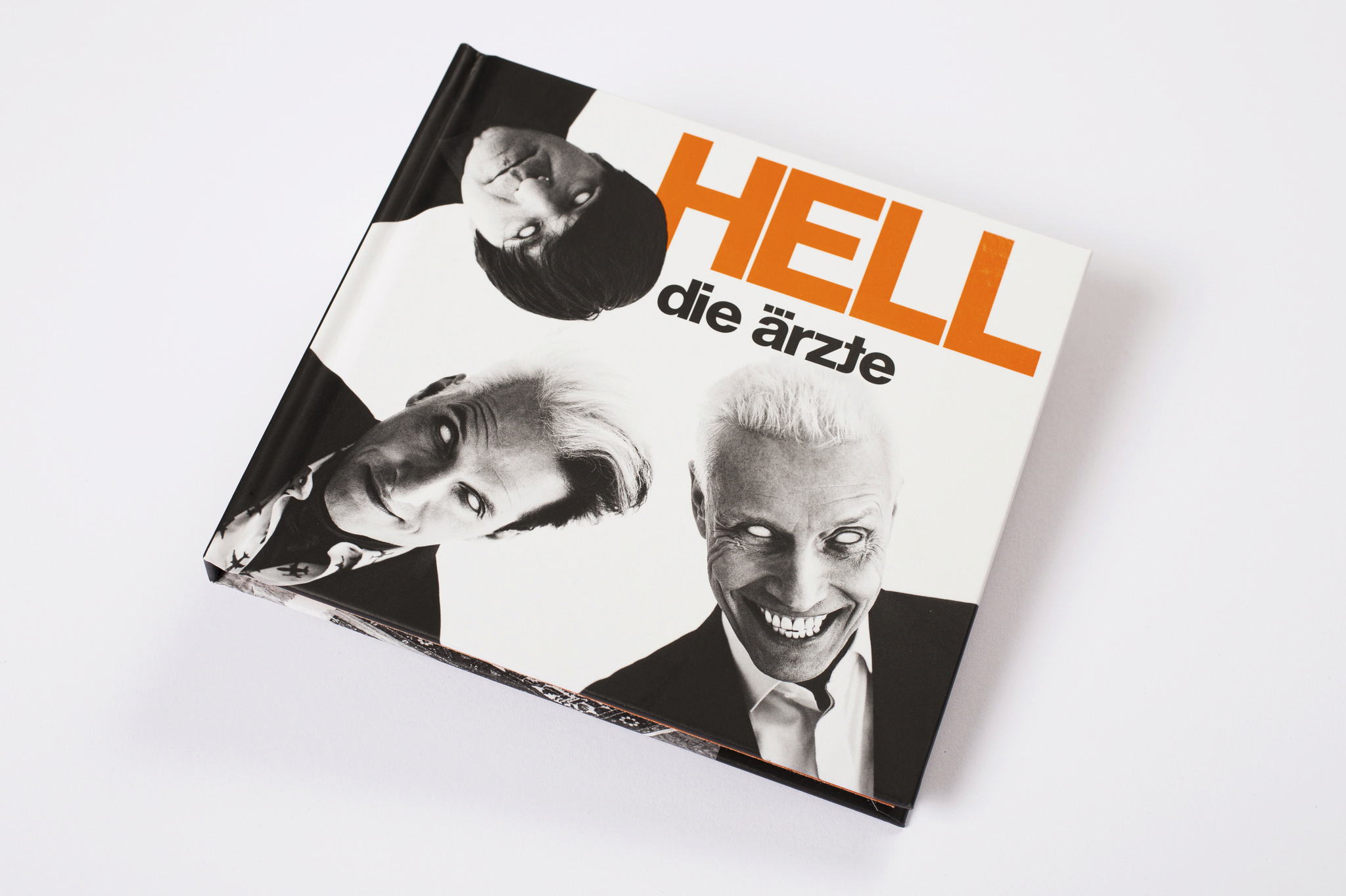 Buchcover mit drei Gesichtern, dem Wort 'HELL' fettgedruckt und dem Bandnamen 'die Ärzte'.