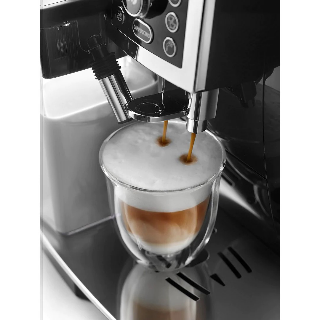 Máquina de espresso dispensando café en un vaso, con un recipiente de leche en el fondo.