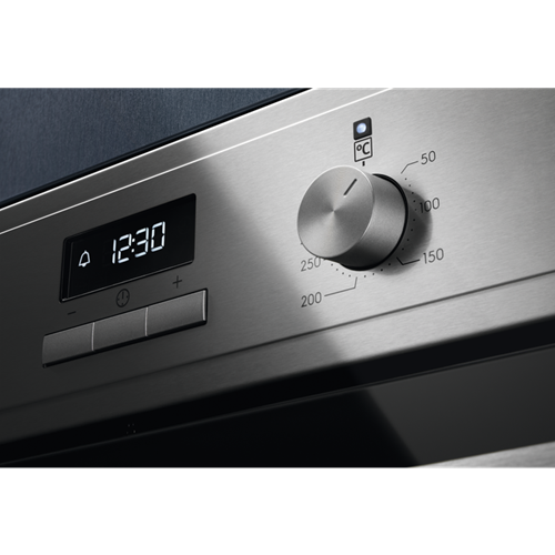 Panel de control del horno: dial plateado con marcas de temperatura, pantalla de reloj digital que muestra las 12:30.