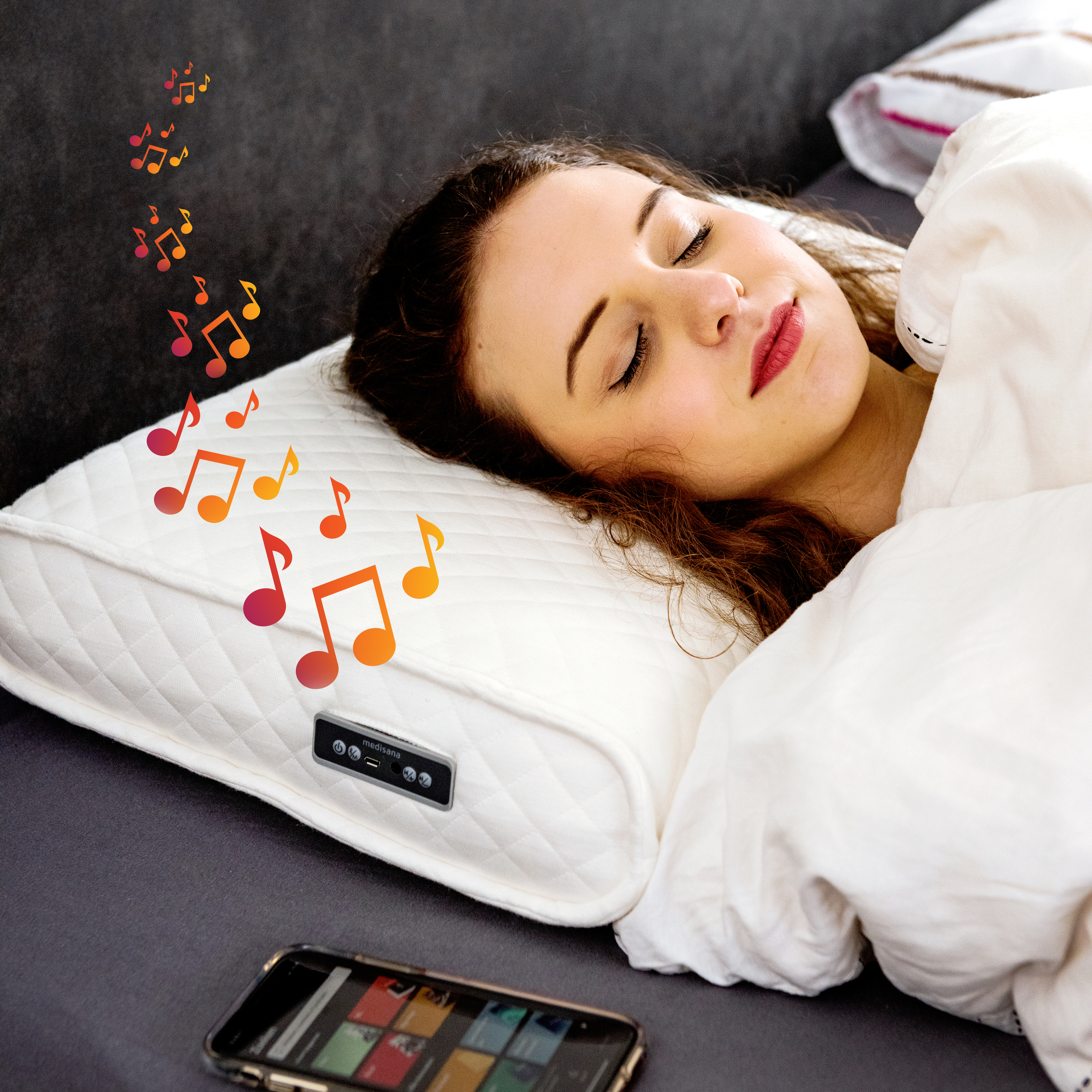 Vrouw slaapt op een bed met een kussen en een telefoon. Muzieknoten zweven boven het kussen. Het bed is bedekt met een witte deken.