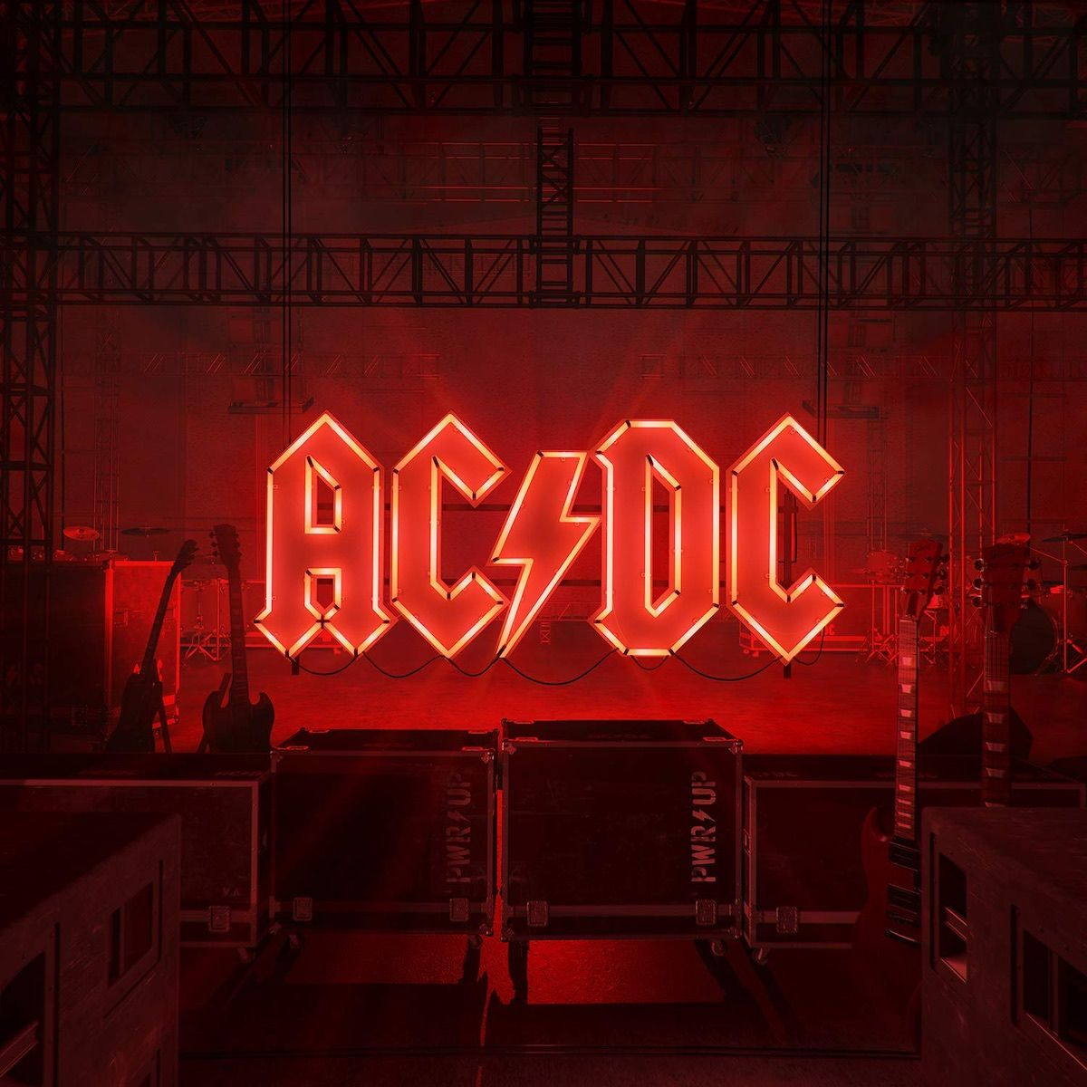 AC/DC-logo in rode neonlichten op een podium. Toneeluitrusting is zichtbaar.