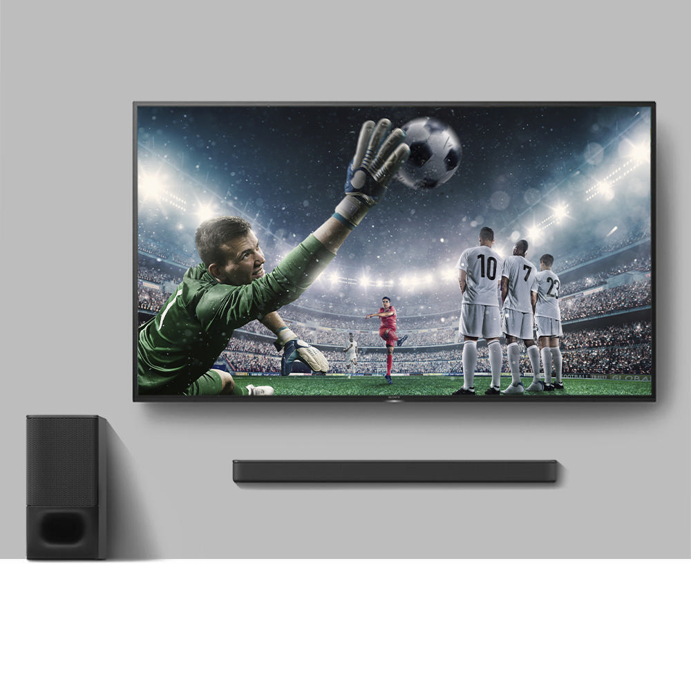 Fußballspiel auf einem Fernseher mit Soundbar und Subwoofer darunter.