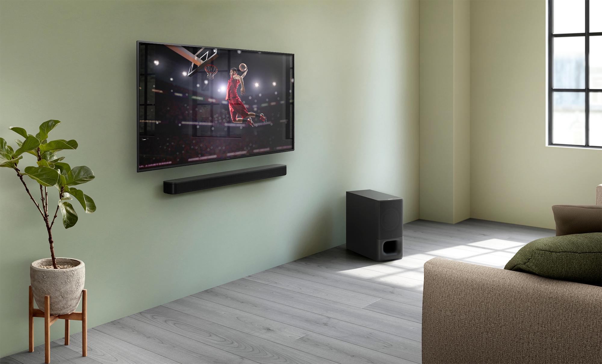 Ein Fernseher zeigt ein Basketballspiel, darunter eine Soundbar und ein Subwoofer.