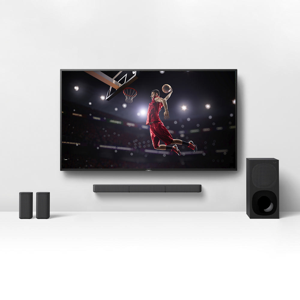Ein Fernsehbildschirm, der einen Basketballspieler beim Springen zeigt, mit Lautsprechern und Subwoofer.