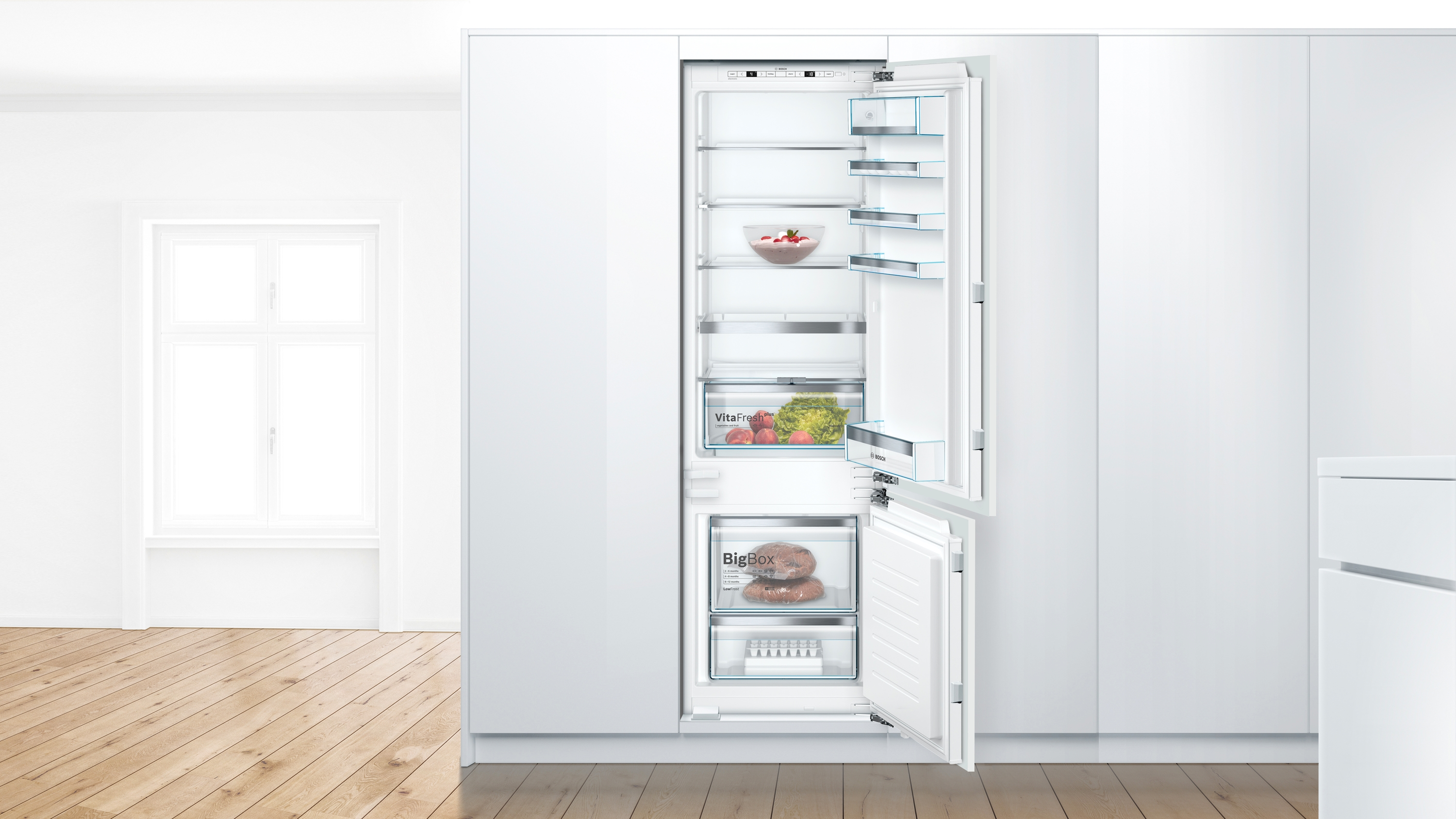 A built-in refrigerator with both doors open, showing shelves, drawers, and contents.