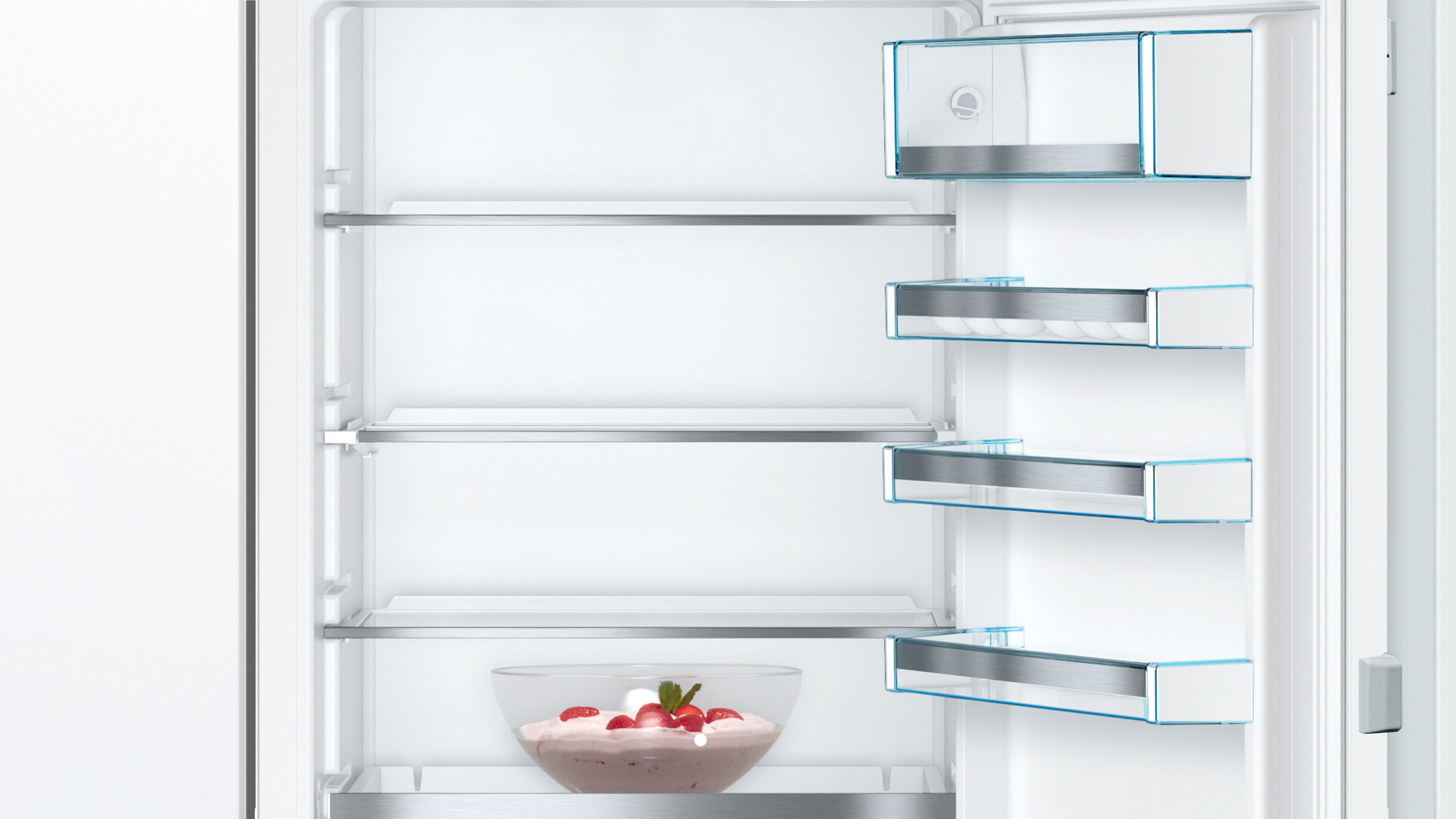 Inside a refrigerator with shelves and a bowl of strawberries.
