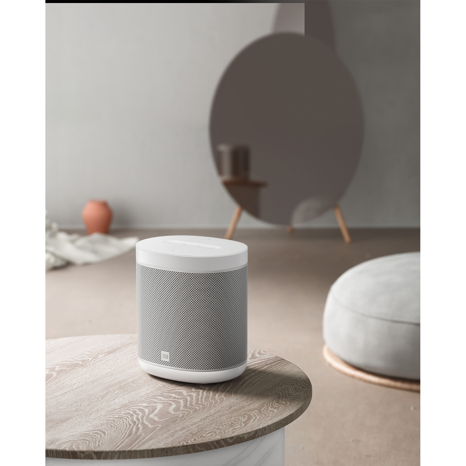 Altavoz blanco sobre una mesa de madera con espejo.