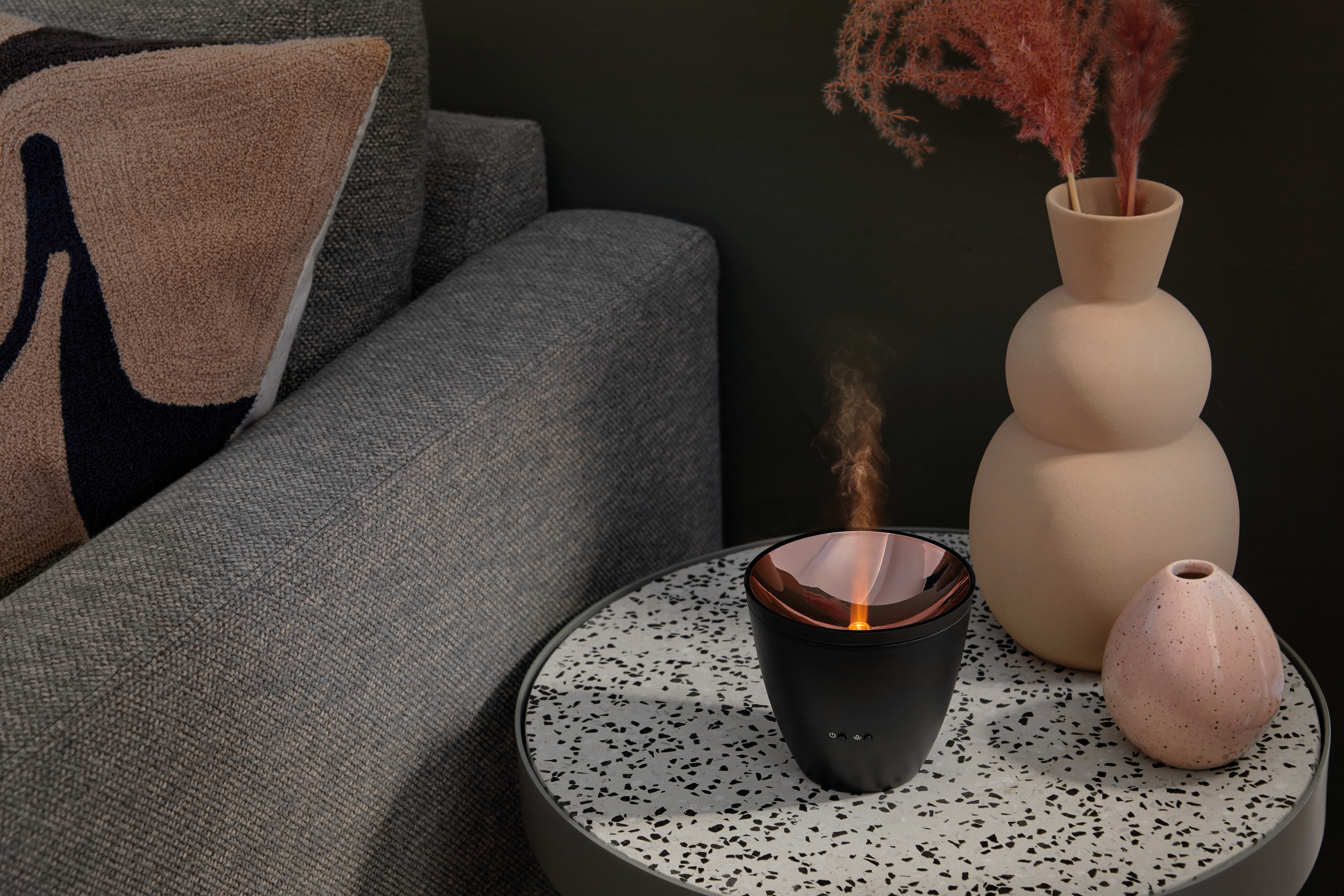 Dekorative Szene: ein Tisch mit Diffusor und Blumen.