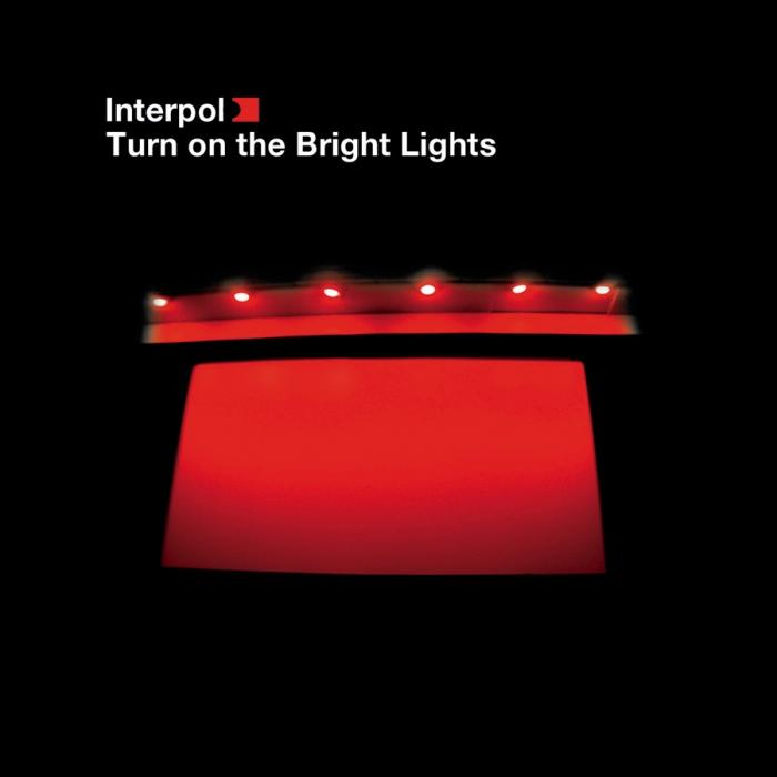 Rode, verlichte rechthoek, Interpol-titel, zwarte achtergrond, donkere scène.