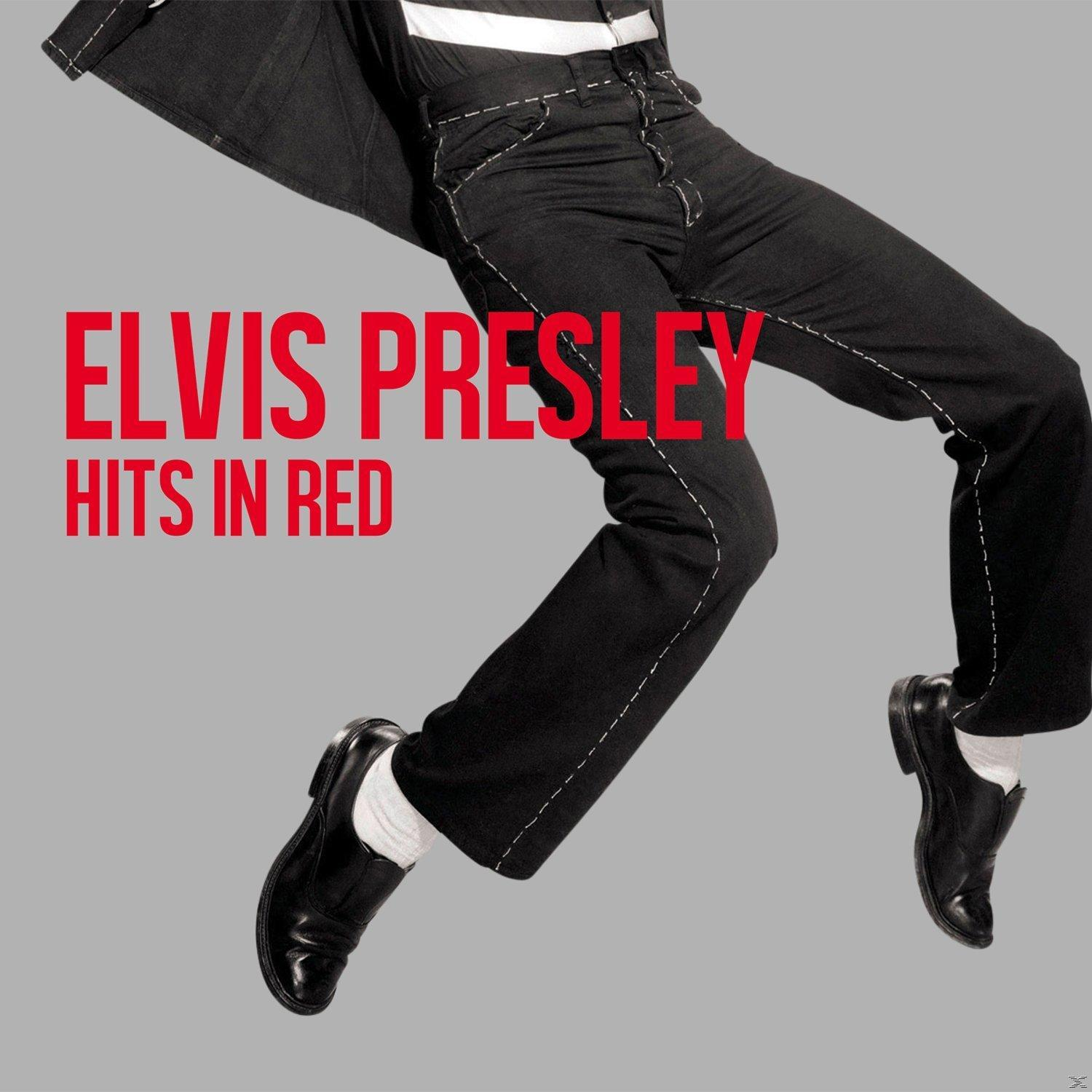Elvis Presley, fekete öltöny, fehér ing, fekete cipő, ugráló póz, piros szöveg: Elvis Presley Hits in Red, szürke háttér.