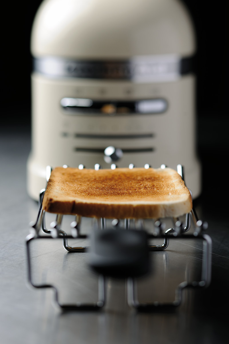 Getoastetes Brot auf einem Rost vor einem cremefarbenen KitchenAid Toaster.
