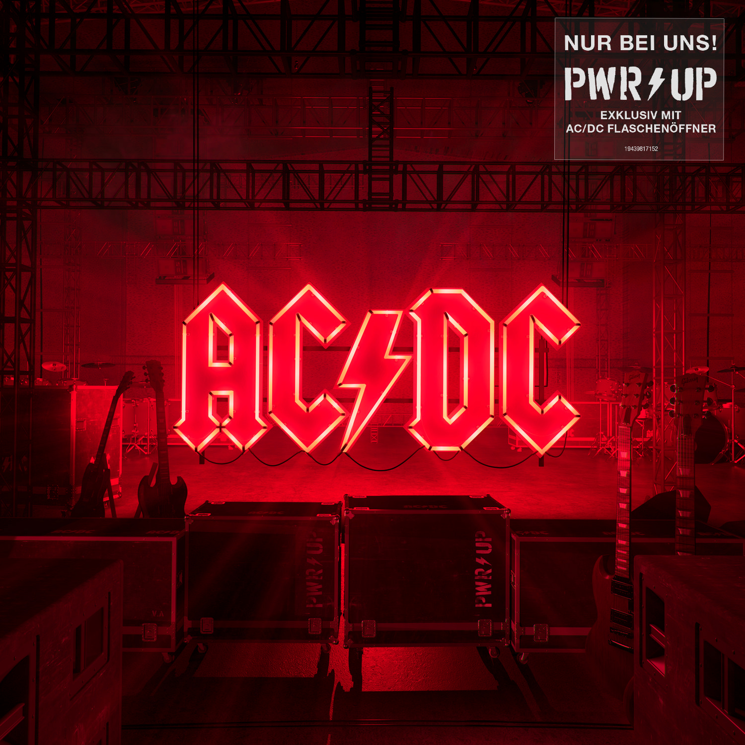 AC/DC-Bühnenaufbau mit Neon-Schild und Bühnenausrüstung. Das Logo ist rot. Lichter im Hintergrund.