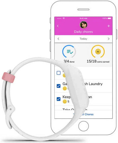 Une montre intelligente blanche à côté d'un téléphone.