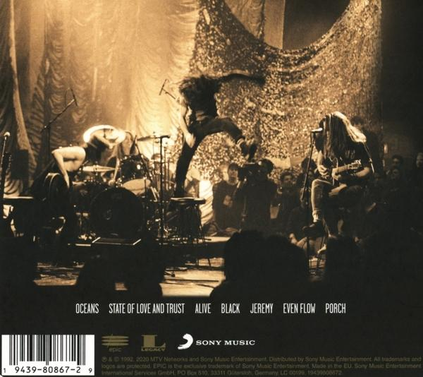 Albumcover mit Bühnenauftritt, Band und Songtiteln.