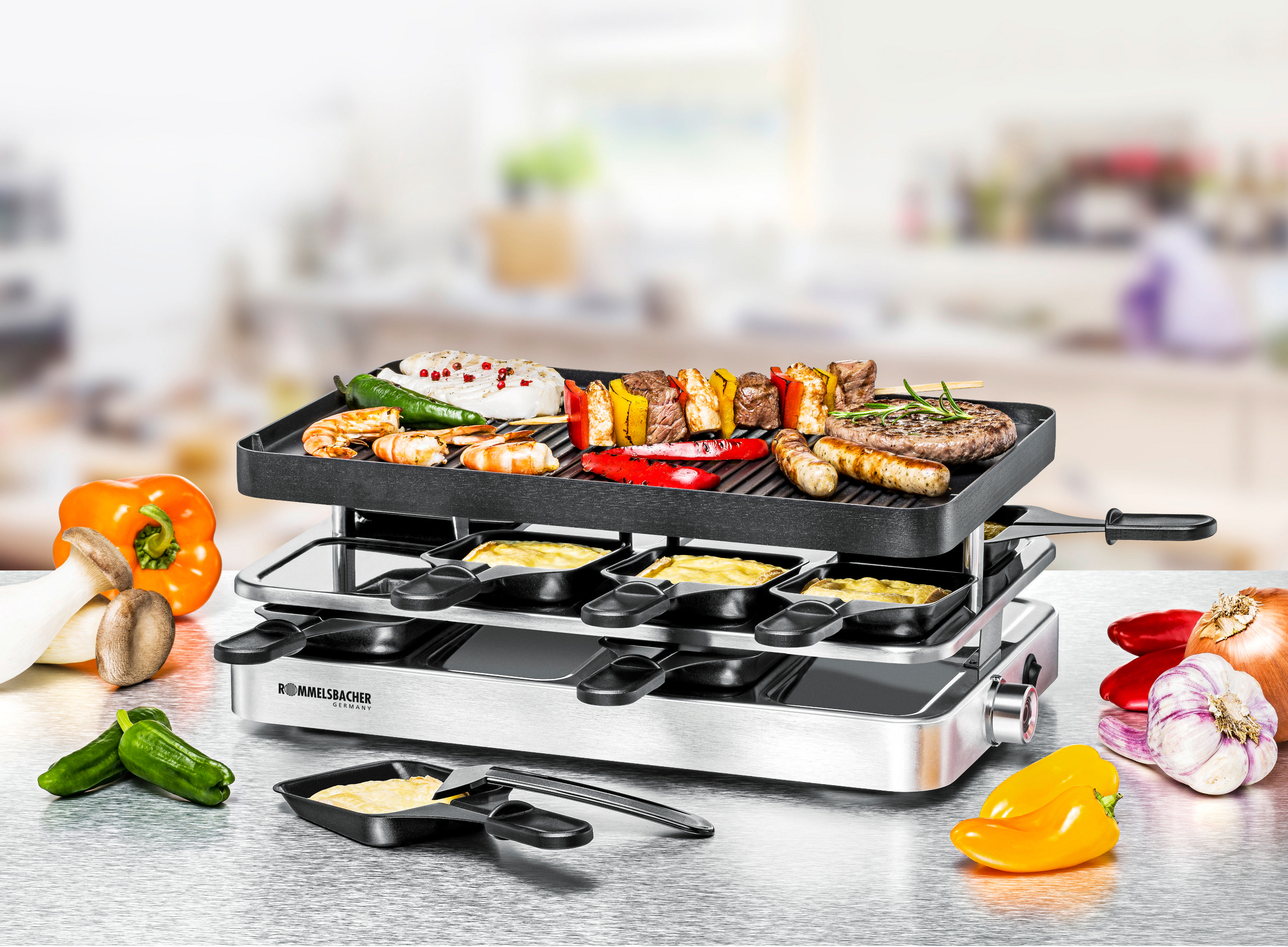 Raclette-Grill mit Essen, Gemüse und verschwommenem Küchenhintergrund.
