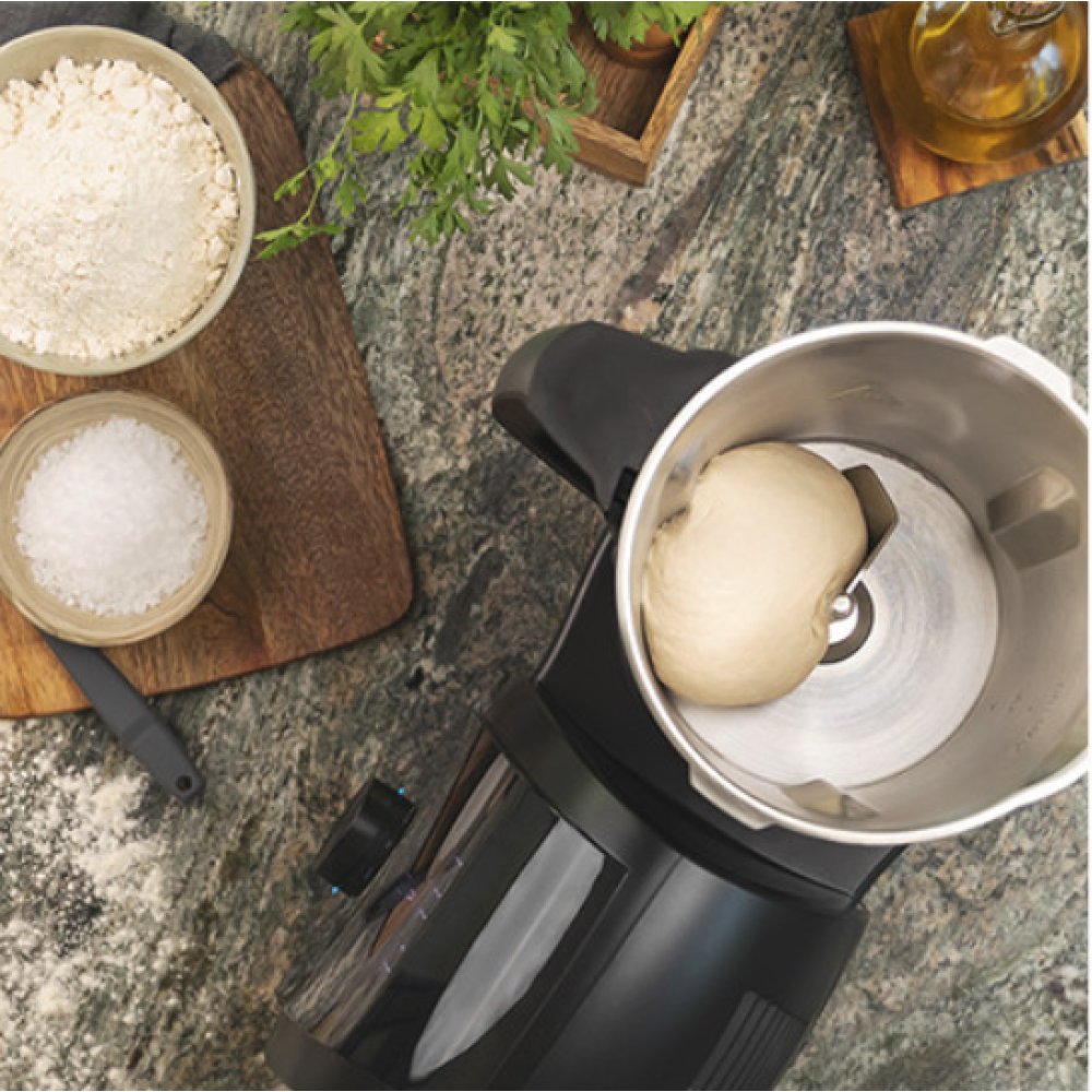 Vista superior de encimera de cocina con ingredientes para masa, incluyendo harina y sal.
