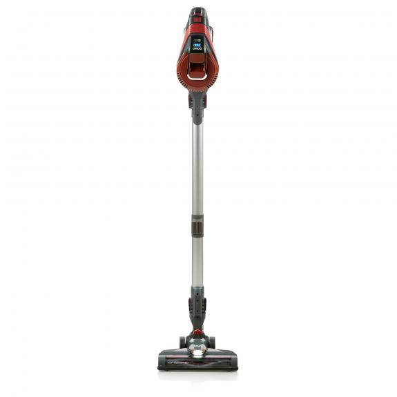 Aspirateur vertical, rouge et argenté. L'aspirateur est doté d'une longue poignée, d'une tête et d'un affichage de la batterie.