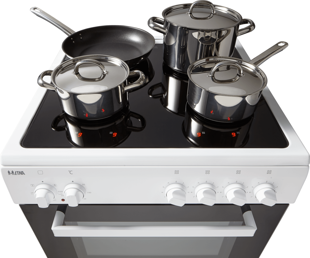 A white electric stove with four burners and stainless steel pots and pans.