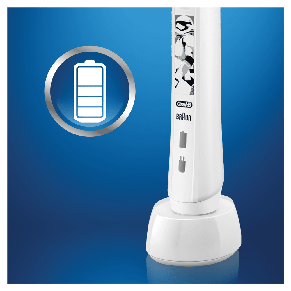 Cepillo de dientes eléctrico Oral-B blanco en una base de carga. Símbolo de batería visible.