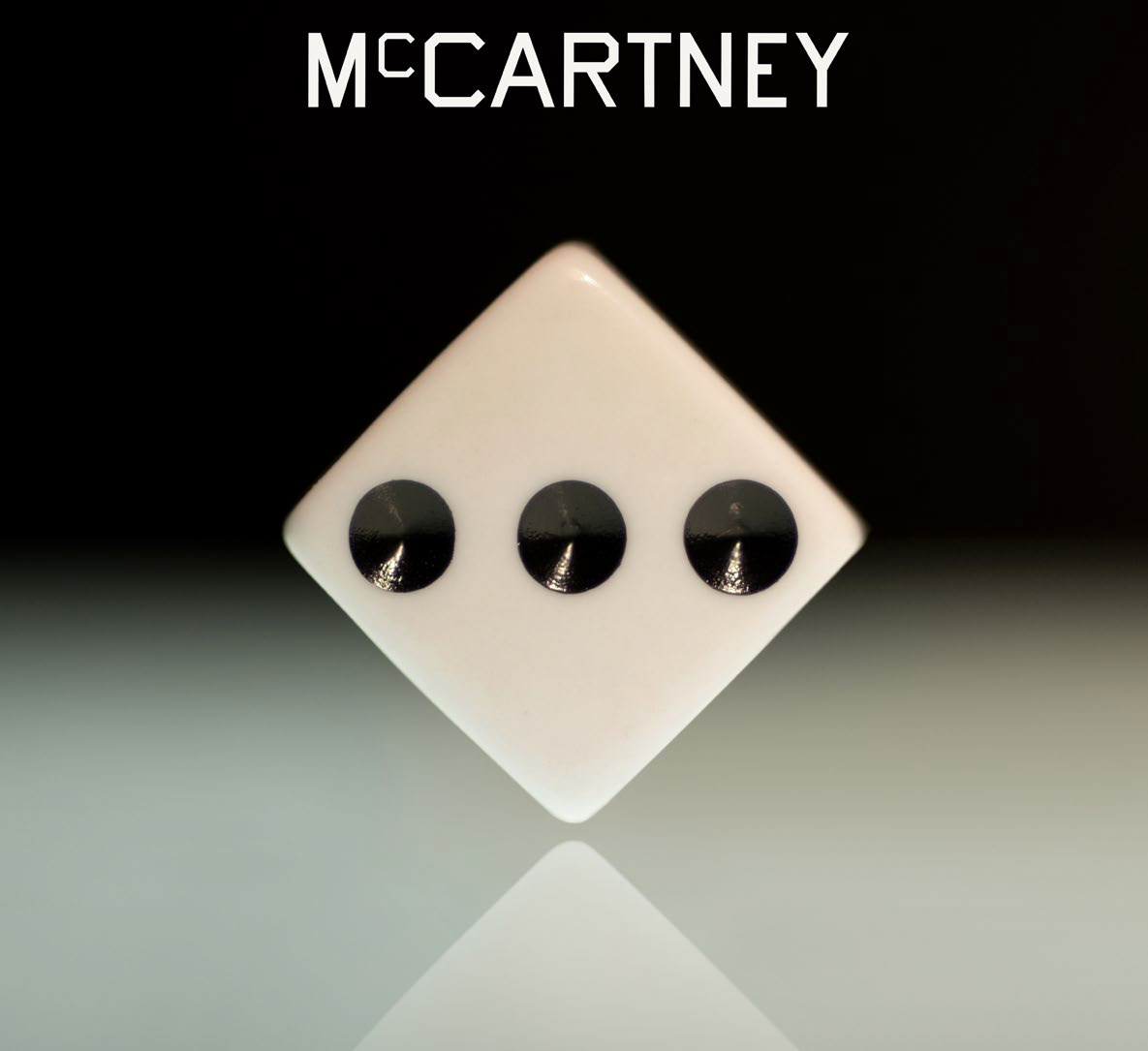Fehér kocka három fekete ponttal. A McCartney név felül van. Fekete háttér.