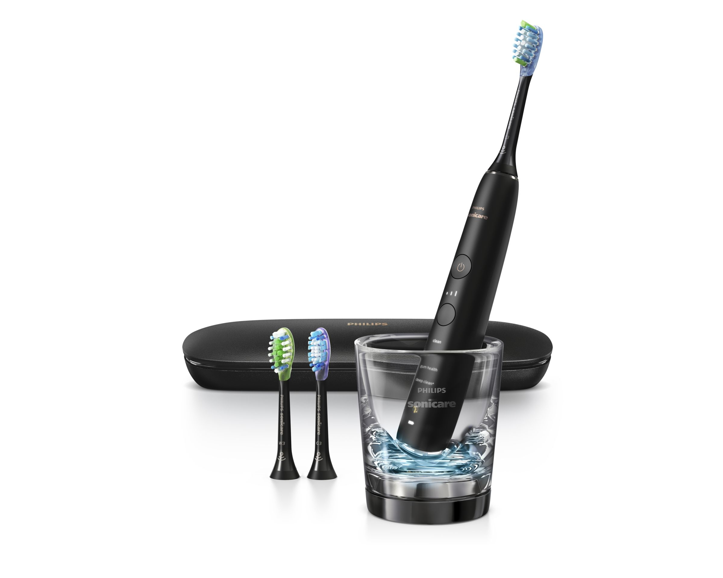 Schwarze elektrische Zahnbürste in einem Glas. Zwei Ersatzköpfe und ein Reiseetui daneben.