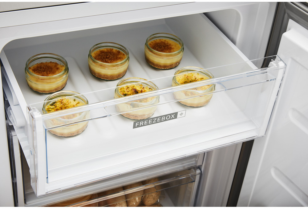 Open koellades met zes crème brûlée desserts. Witte achtergrond.