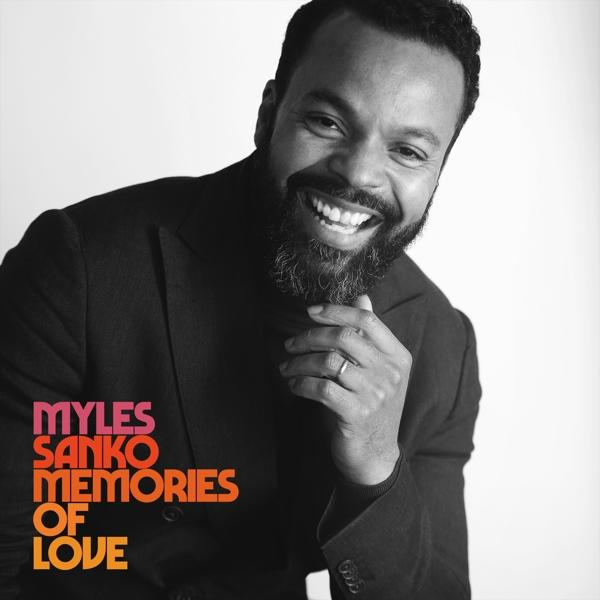 Ein lächelnder Mann mit Bart. Text links sagt 'Myles Sanko Memories of Love'.