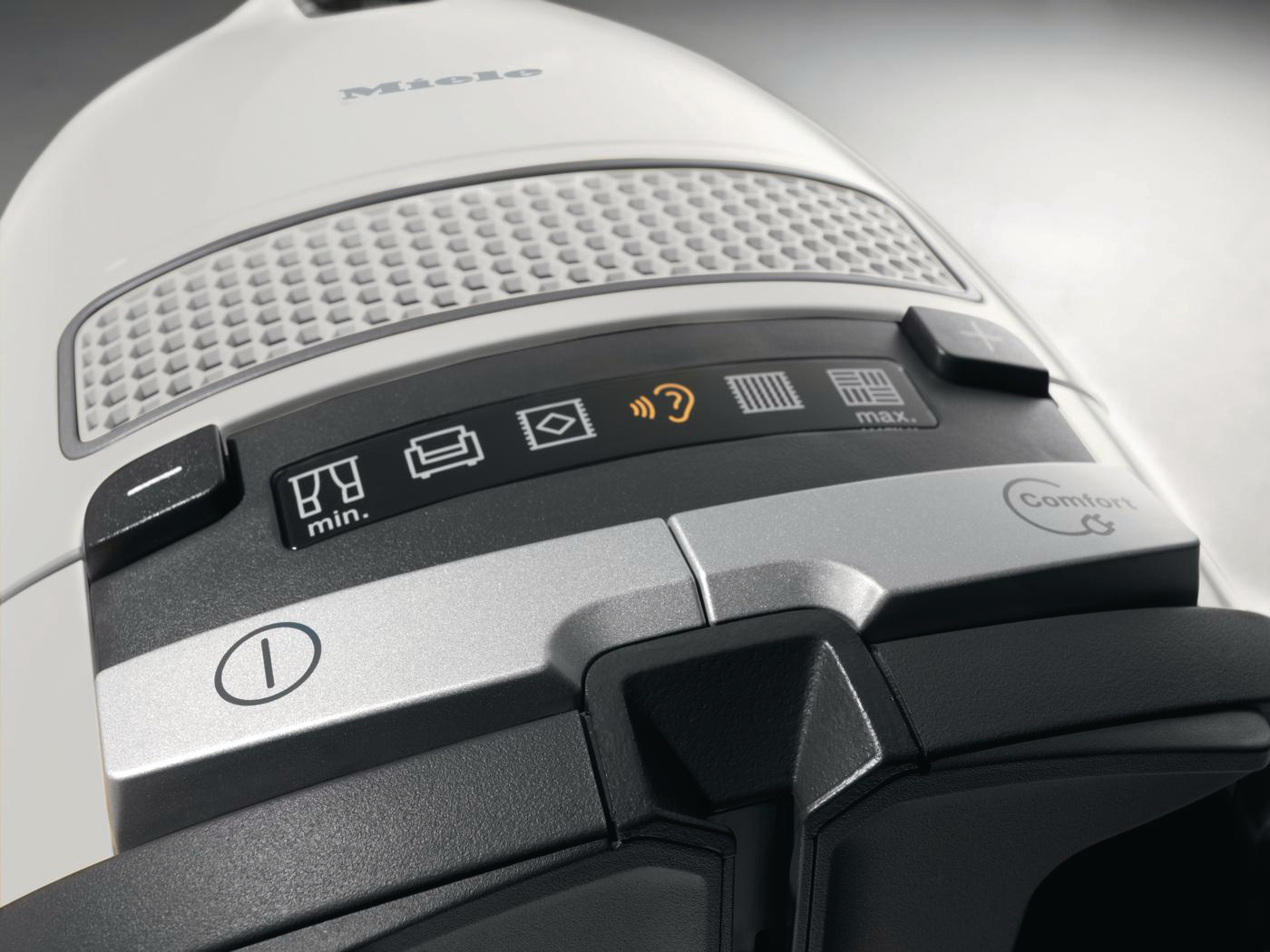 Nahaufnahme eines weißen Miele-Staubsaugers mit Bedienknöpfen. Das Miele-Logo ist sichtbar.