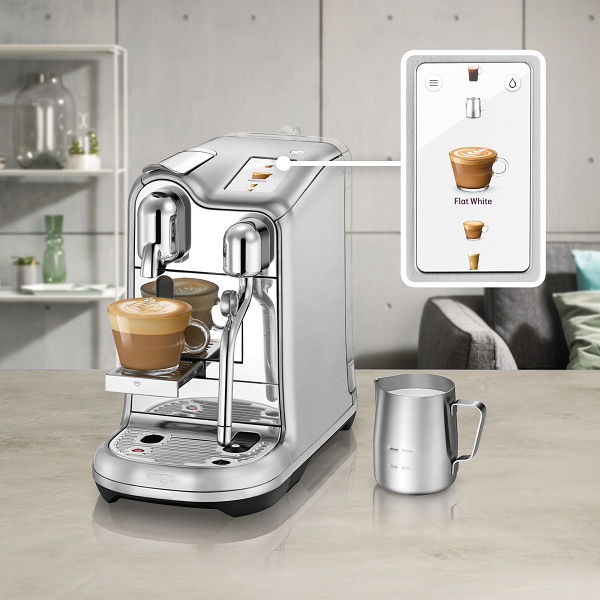 Silberne Kaffeemaschine mit einer Tasse Kaffee. Ein Touchscreen zeigt verschiedene Kaffeesorten.