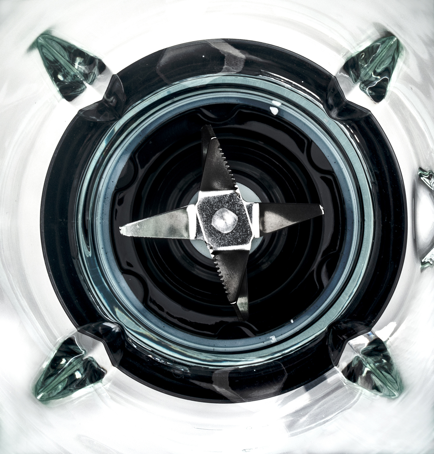 Blender interior view. Blades in the center. Dark interior, light reflections. Glass container.