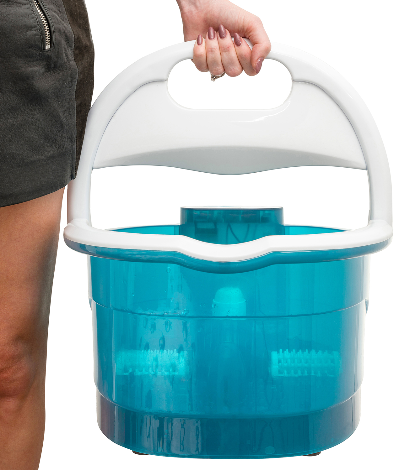 A woman holds a blue foot spa with a white handle. She wears a skirt. The spa has brushes inside.