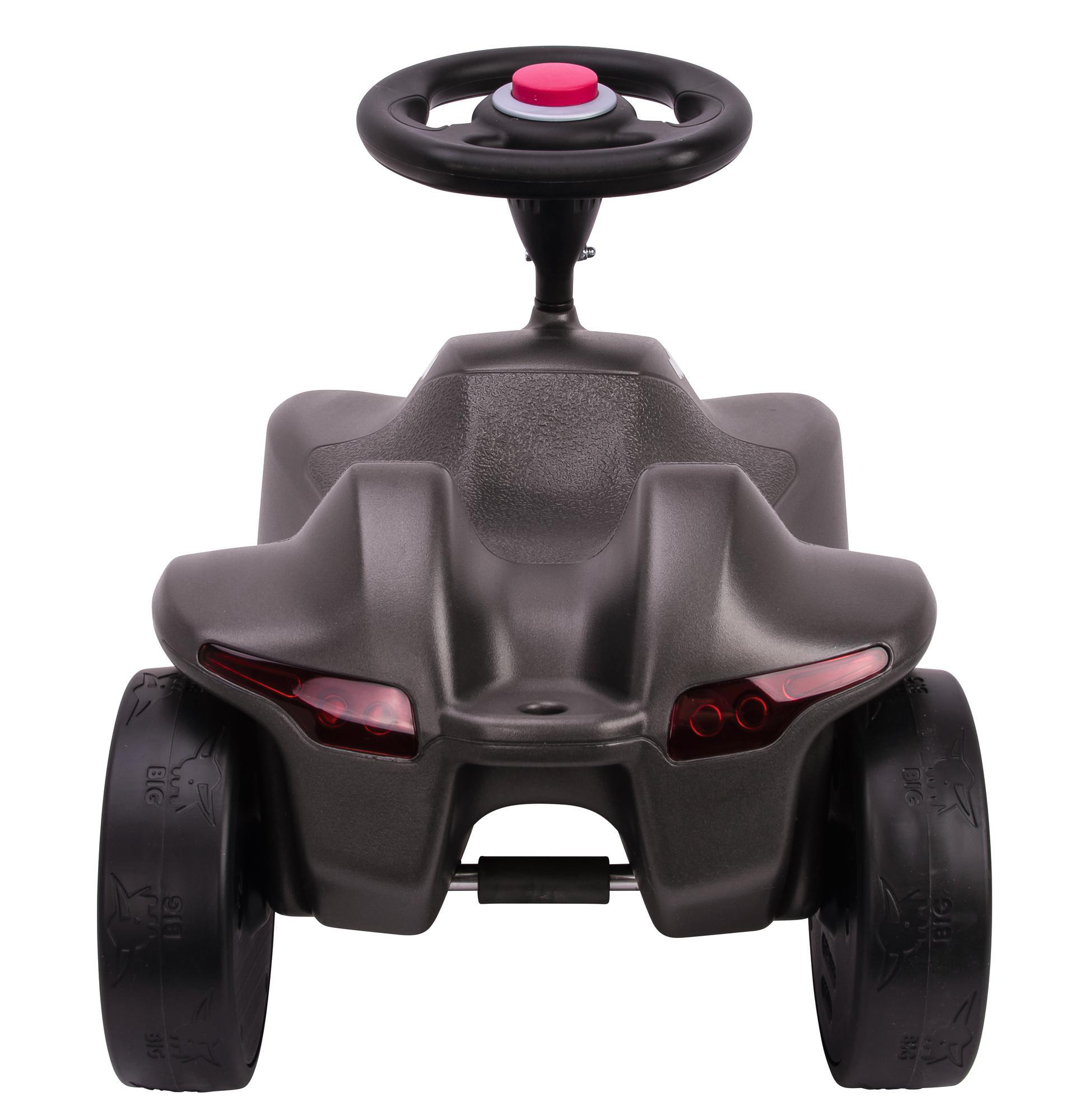 Ein graues Spielzeugauto für Kinder. Es hat ein Lenkrad und rote Lichter.