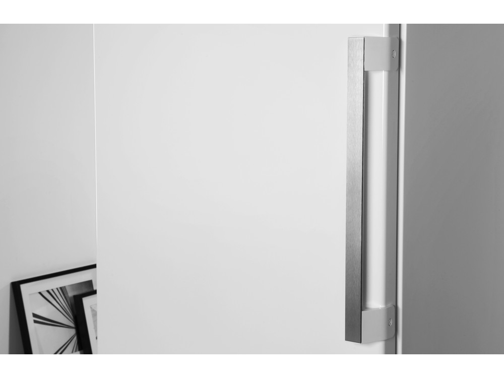 Una puerta blanca con un tirador plateado en el lado derecho. Hay un marco de fotos a la izquierda.