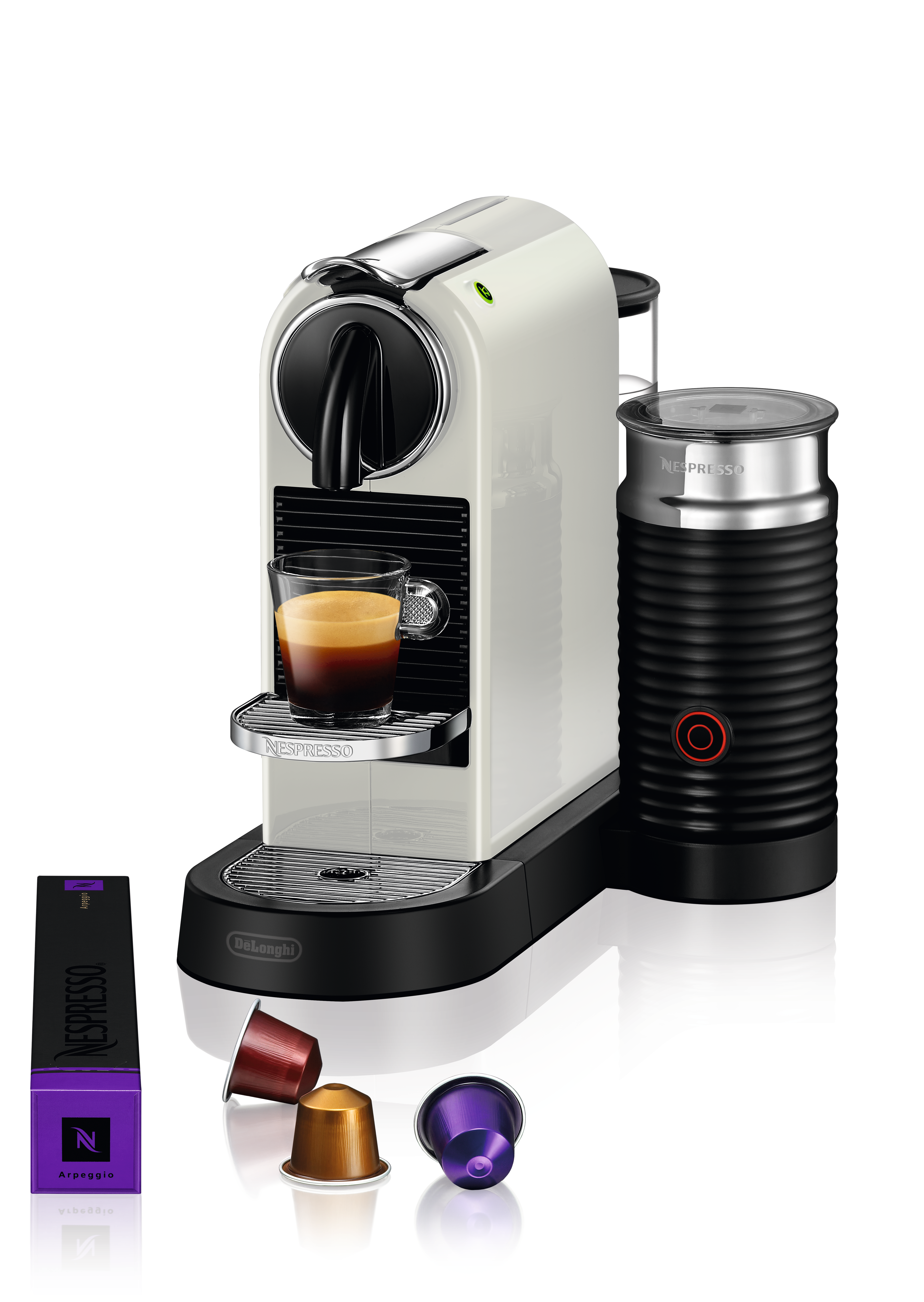 Nespresso-Maschine, weiß und schwarz. Glas Kaffee und Milchaufschäumer. Mehrere Kapseln.