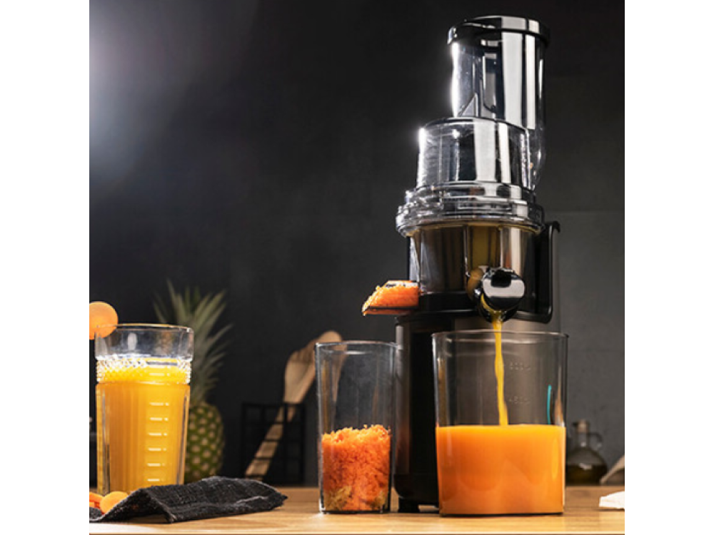 Se está vertiendo jugo de una exprimidora en un vaso, con otros ingredientes a la vista.