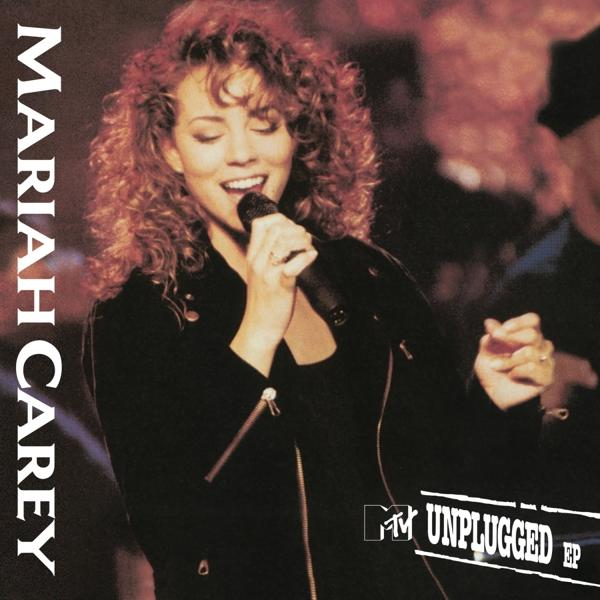 Mariah Carey Albumcover. Sie steht auf der Bühne und singt in ein Mikrofon. Schwarzes Outfit, lockiges Haar.