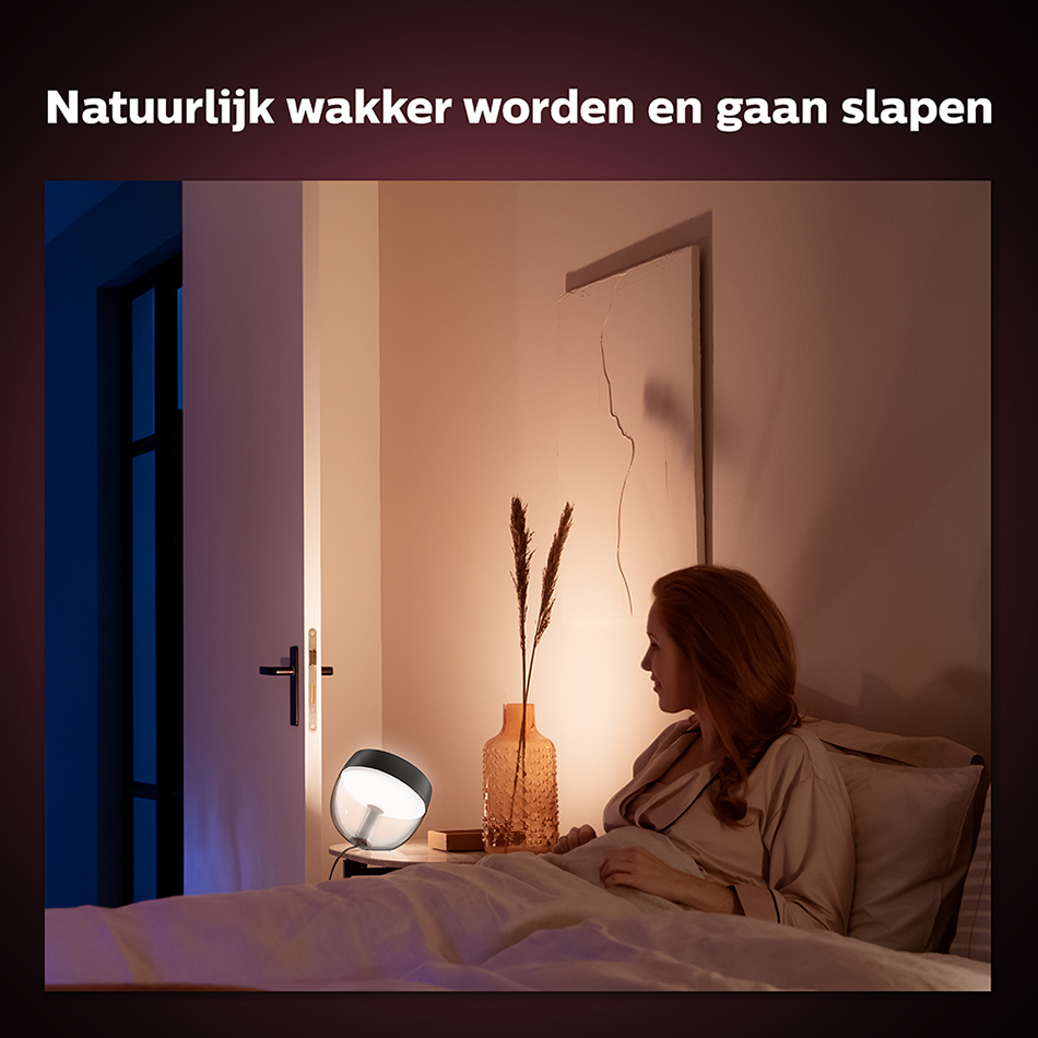 Een vrouw in een slaapkamer met een lamp. De tekst hierboven zegt: 'Natuurlijk wakker worden en gaan slapen'.