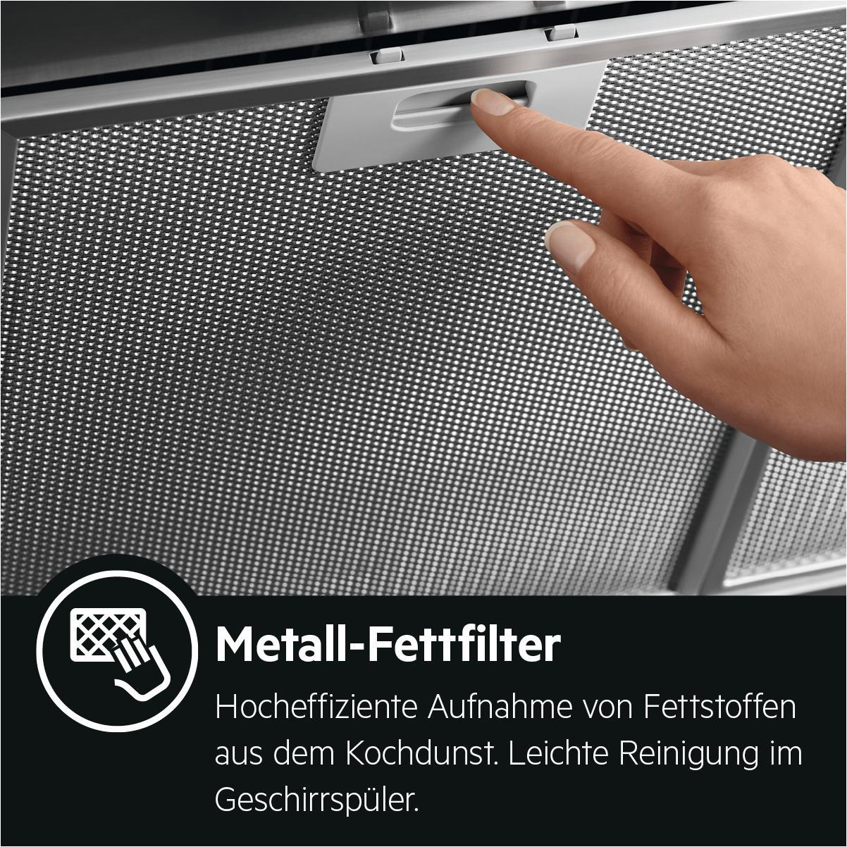 Eine Hand berührt einen Metallfettfilter mit Text darunter.