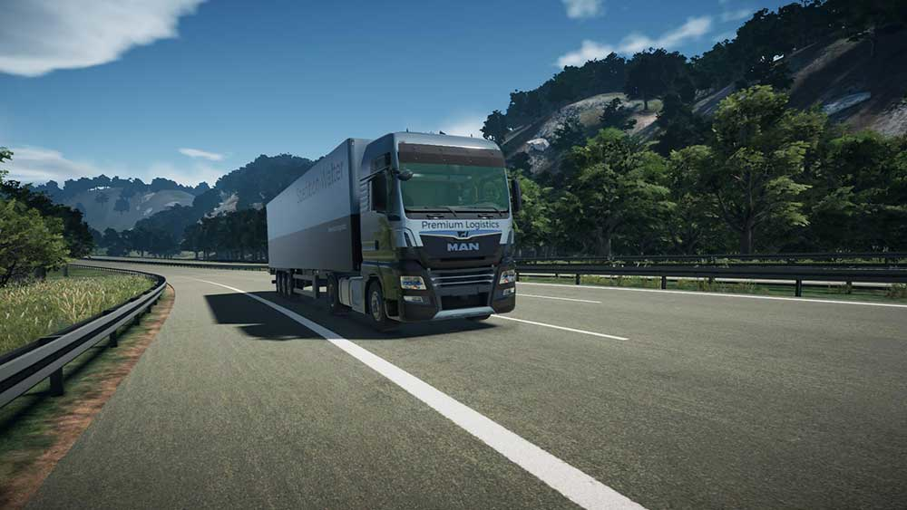 Camion sur une autoroute, avec des arbres verts et des collines en arrière-plan.