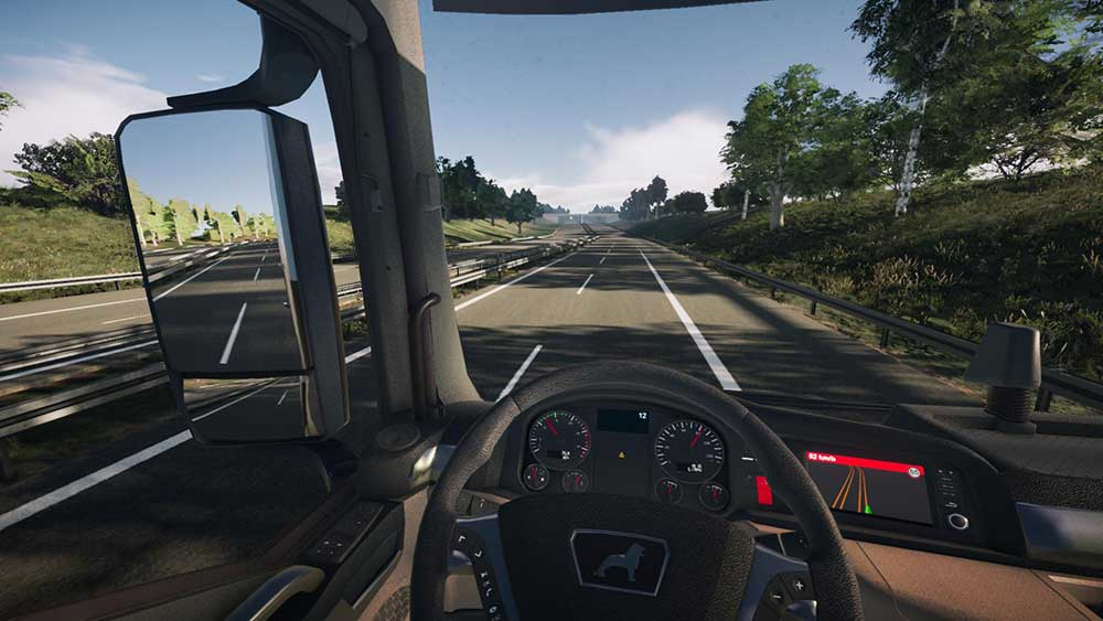 Vue intérieure d'une cabine de camion roulant sur une autoroute. Pare-brise et tableau de bord visibles.