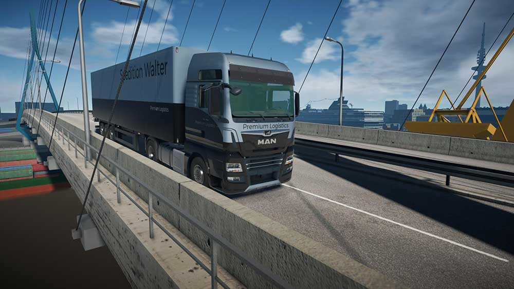 Un camion avec remorque roulant sur un pont, avec ville et eau en arrière-plan.