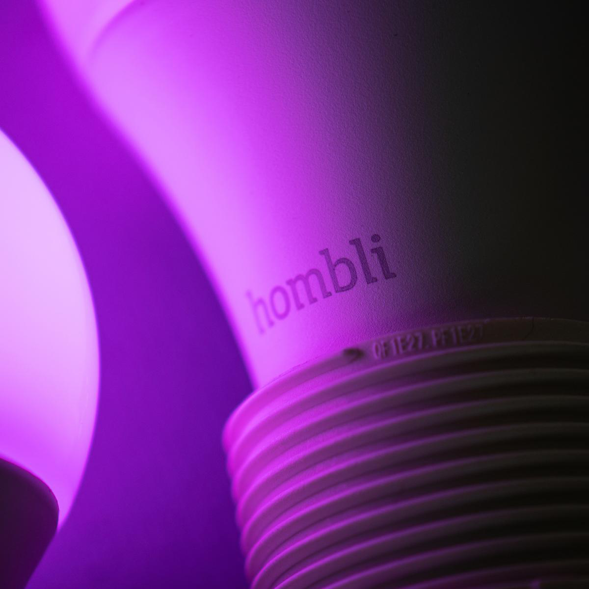 Nahaufnahme einer weißen Smart-Glühbirne mit 'hombli'-Aufdruck, die violett leuchtet.