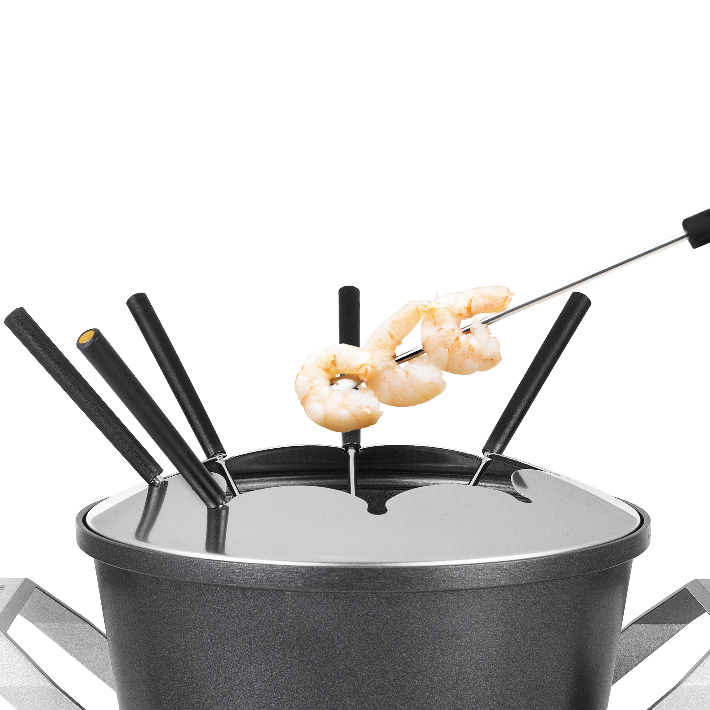 Shrimp being dipped into a fondue pot with fondue forks.