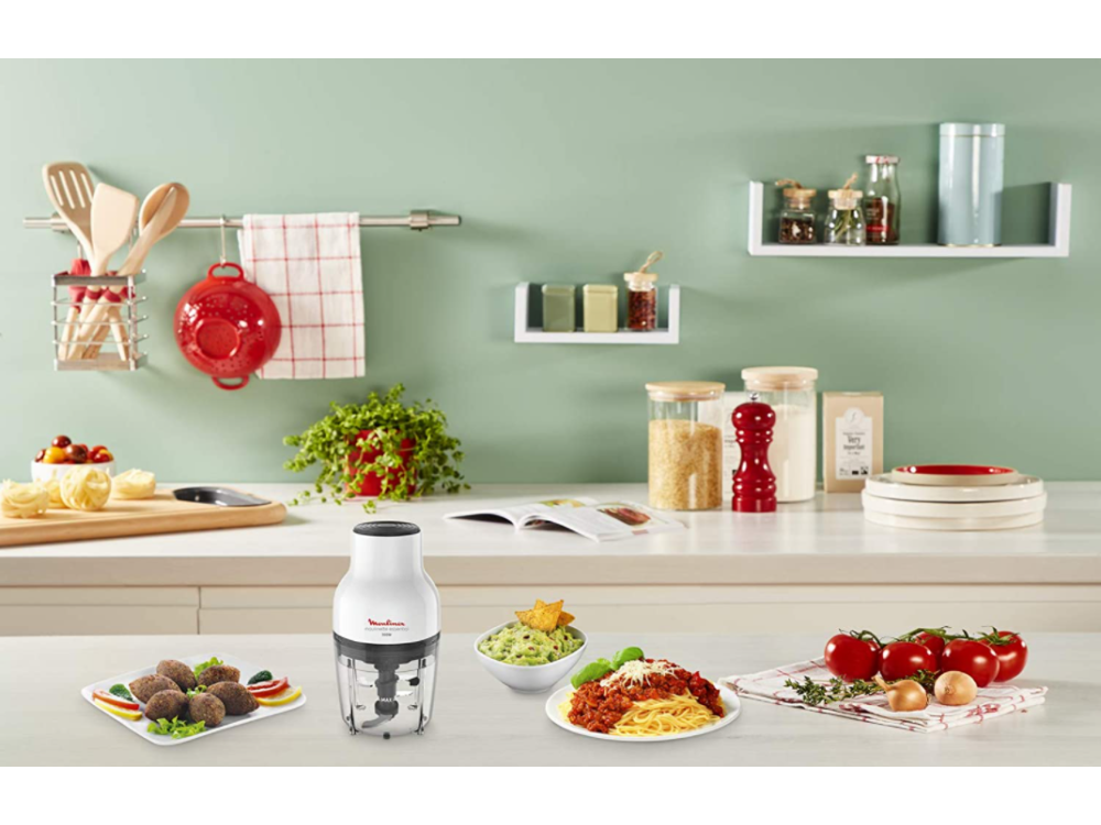 Escena de cocina con comida, ingredientes y un procesador de alimentos blanco y negro.